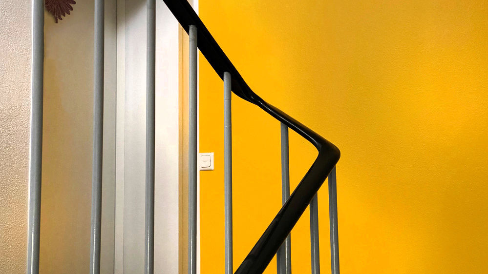 Treppenlauf vor einer gelben Wand