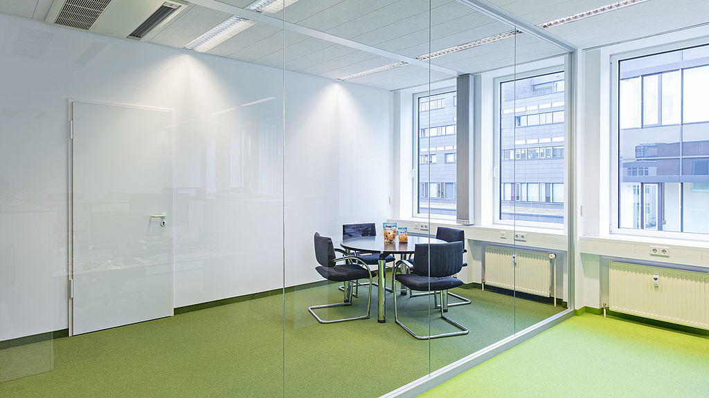 Büro mit grünem Fußboden, Schreibtisch und Stuhl