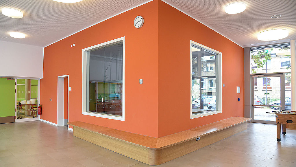 Büro in einer Schule mit orange gestrichenen Wänden