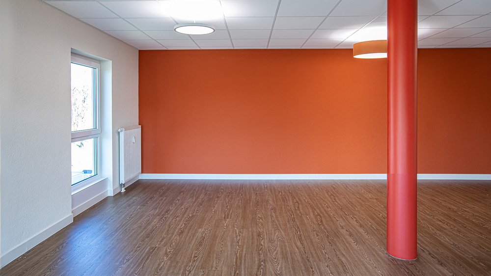 Orange gestrichene Wand in einem sanierten Raum