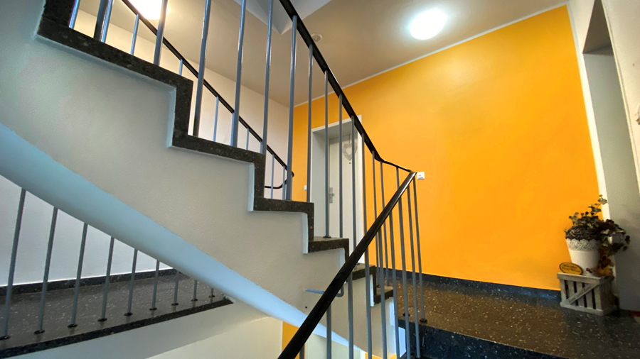 Nahaufnahme einer Treppe in einem Treppenhaus mit gelben Wandelementen